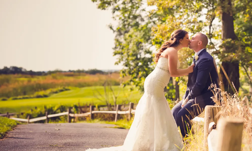 Wedding couple kissing in front of the golf course at Ballyowen