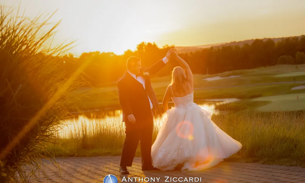 Groom twirling his bride with sunsetting