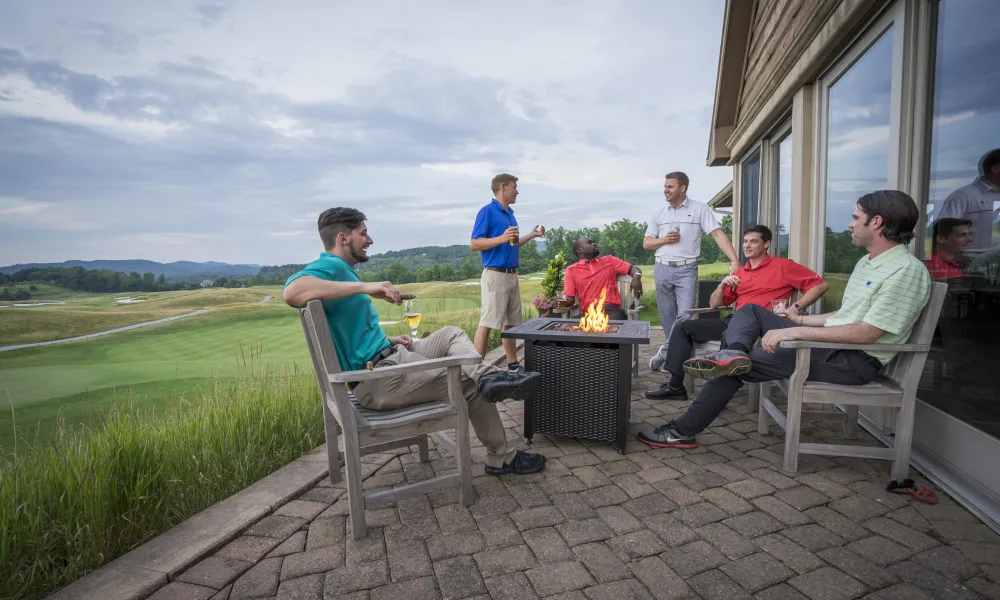 Men sitting at fire pit outside of Ballyowen Clubhouse