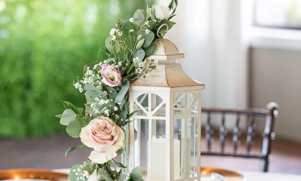 Wedding table centerpiece of flowers wrapped lantern