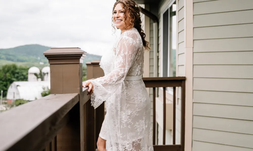 Beautiful bride in wedding dress standing looking over balcony