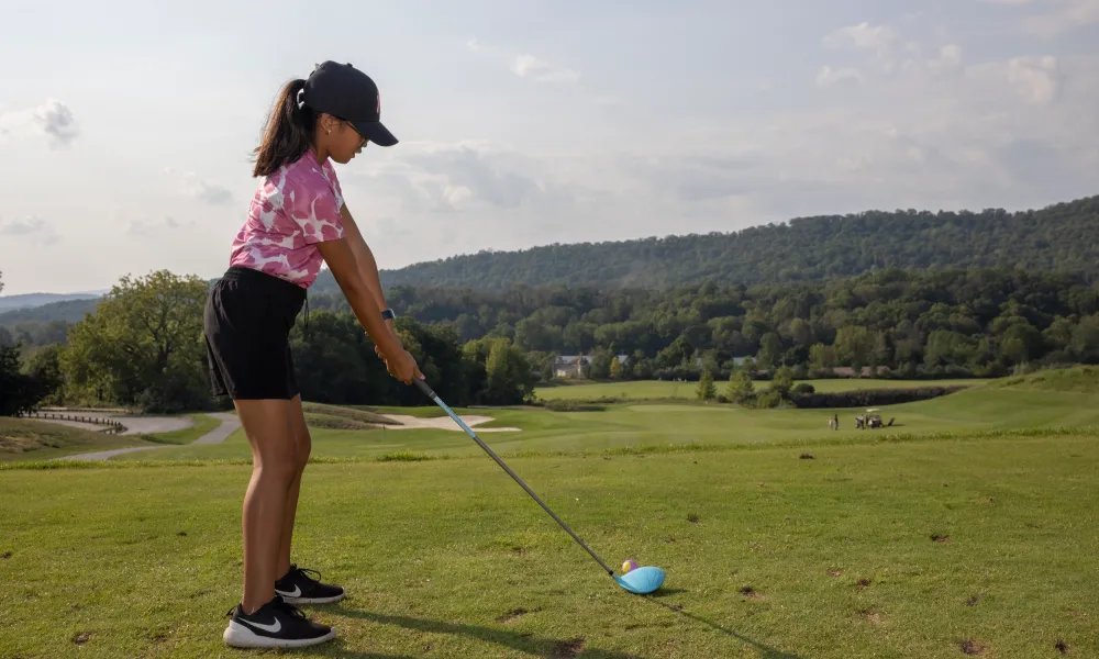 Young girl lining up her swing to golf