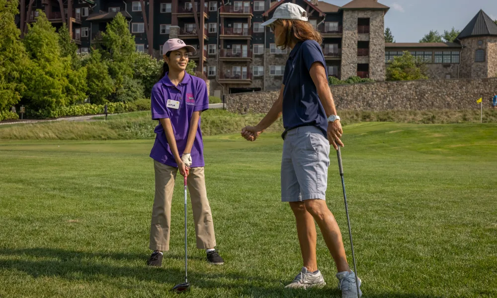 Golf instructor teaching girl to golf at Crystal Springs Resort