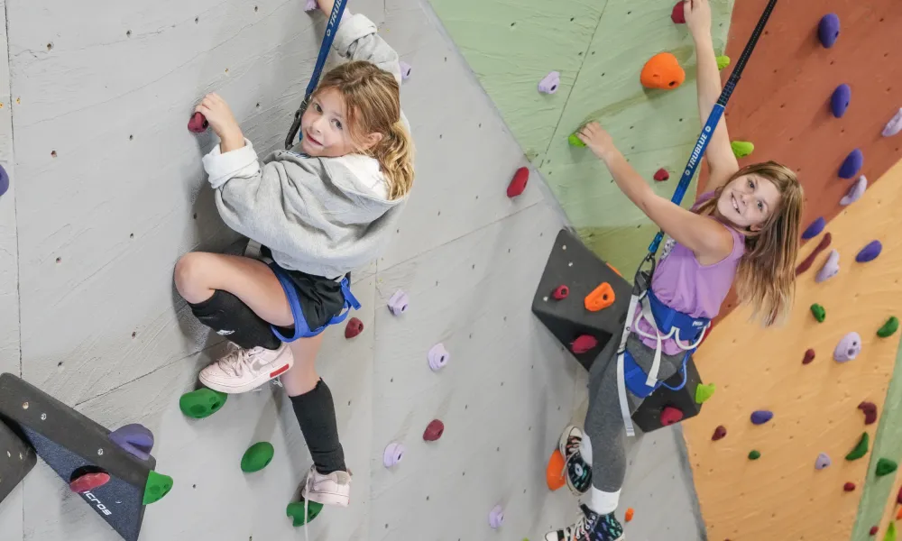 Two girls rock climbing.