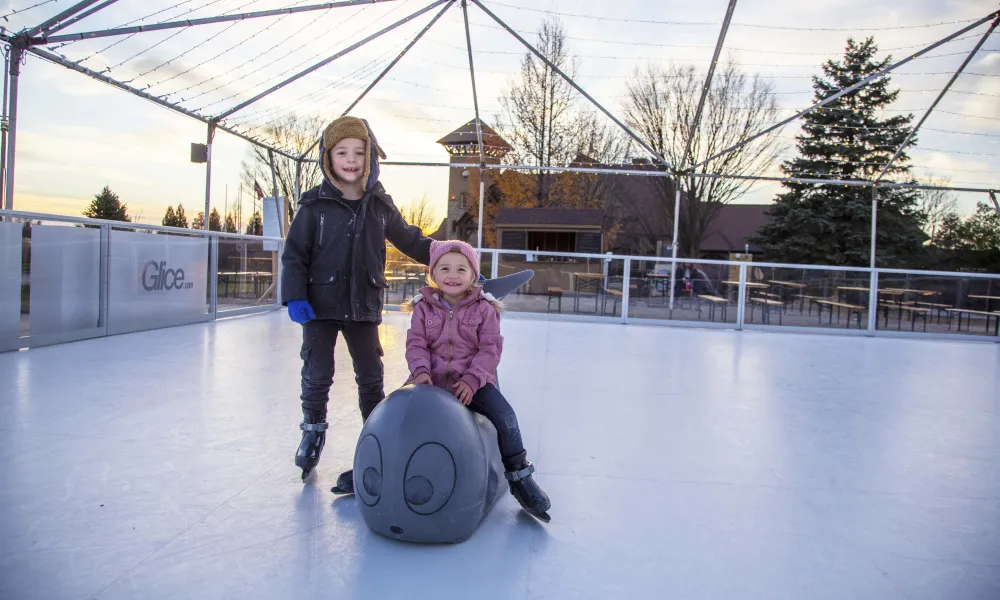 Two children glice skating.