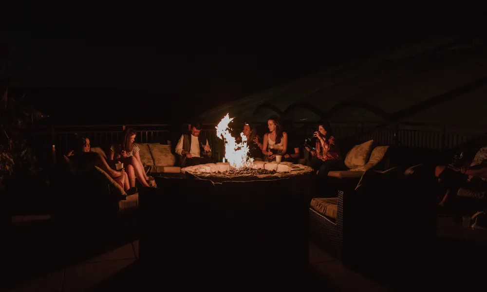 Group roasting marshmallows at the firepit at Grand Cascades Lodge