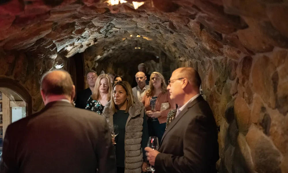 Group of people taking a wine cellar tour.