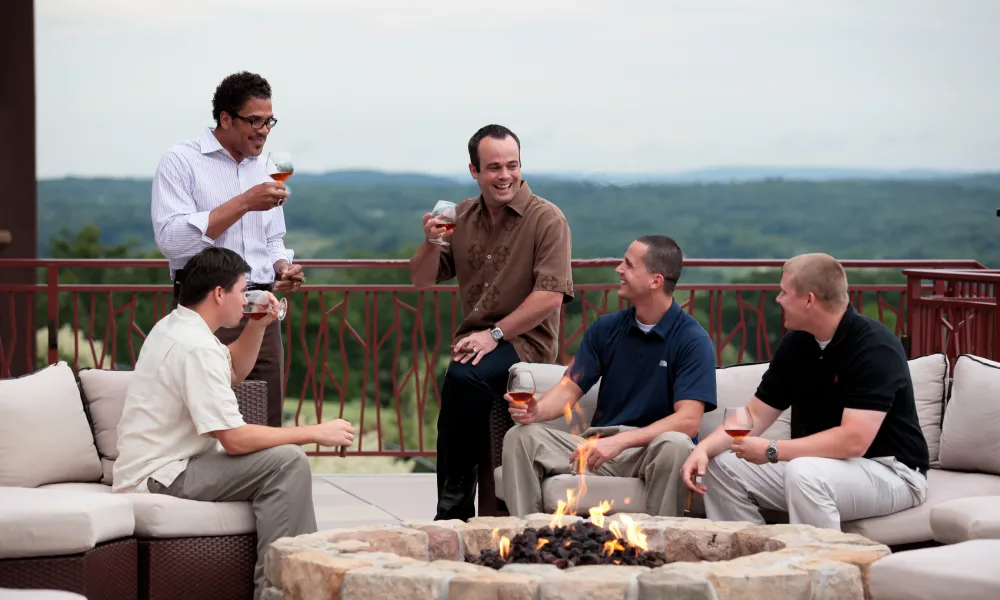 Group of guys hanging out by the firepit