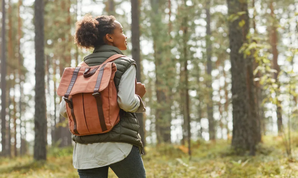 Woman hiking through forest in Sussex County.