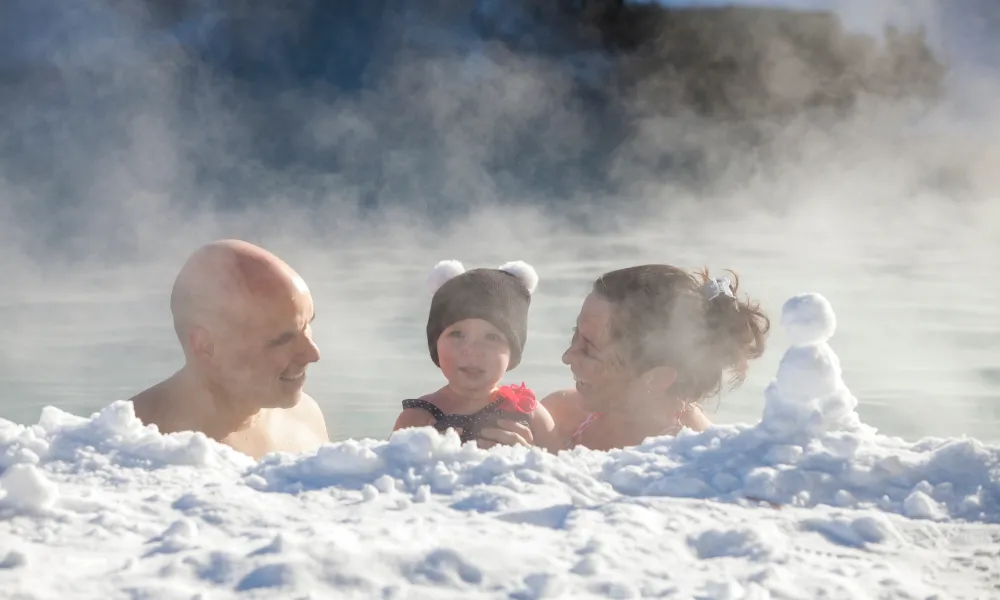 Parents and child swimming in snow pool at Minerals Hotel