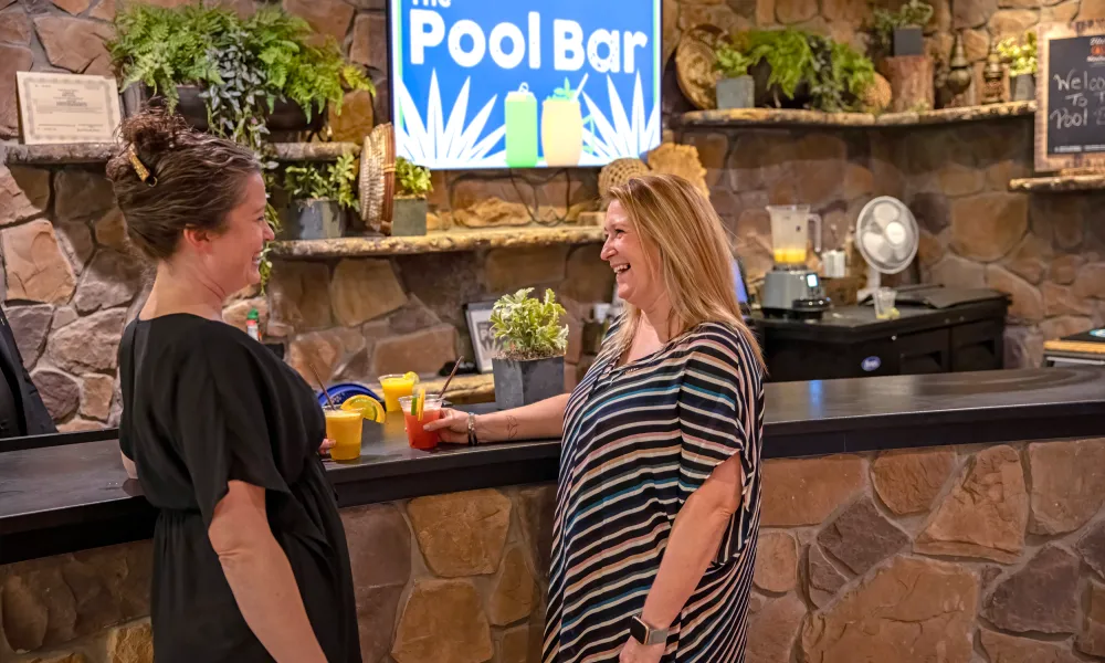 Two women enjoying drinks at The Pool Bar