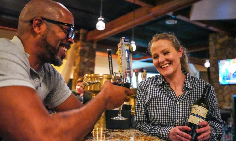 Bartender serving red wine to man at Kites Restaurant