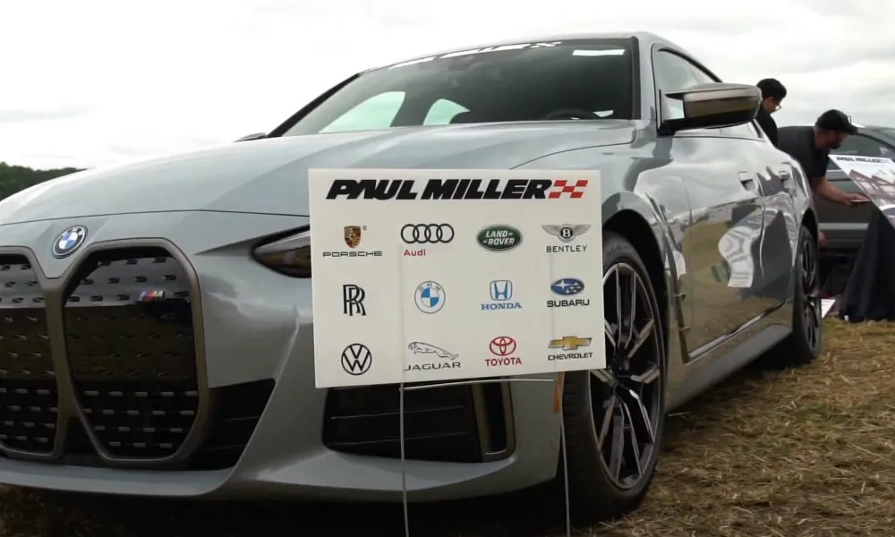 Gray bmw with Paul Miller Dealership sign in front of it.