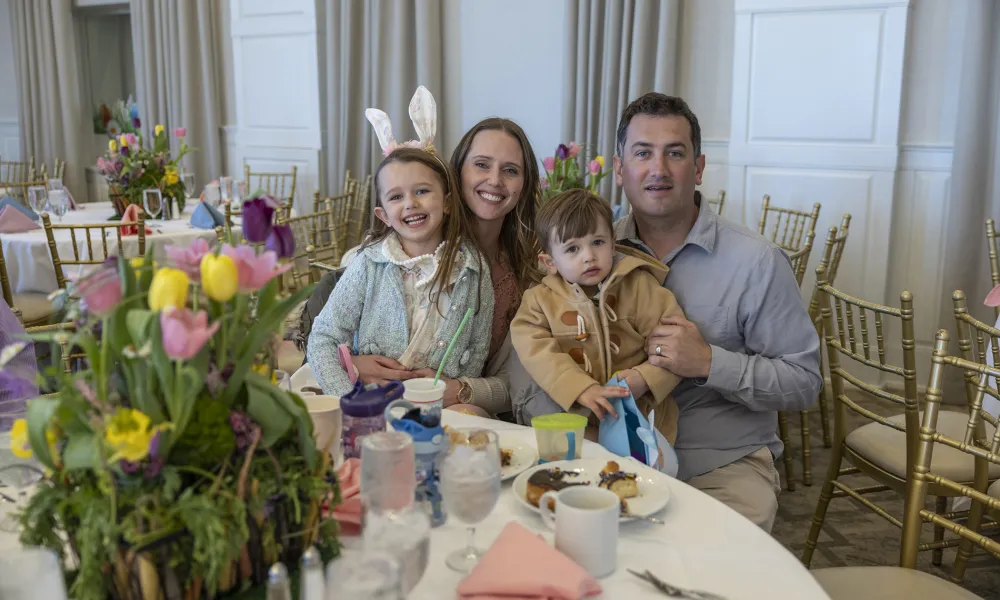 Family of four sitting at round easter dining table.