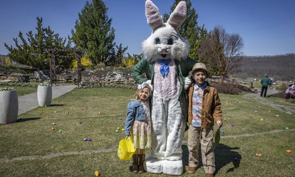 Two children standing with Easter bunny.