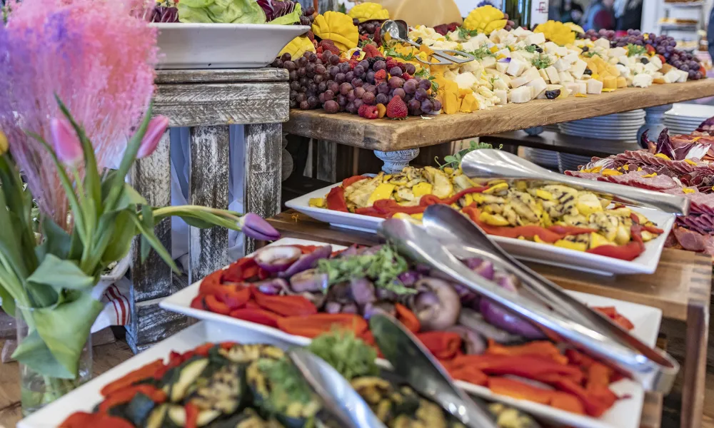 Food display of cheese, fruit and array of other things.