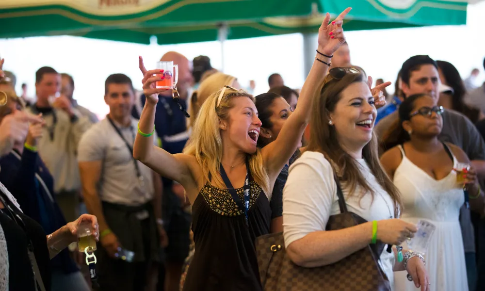 Woman with beer tasting in her hand singing at NJ Beer and Food Festival.