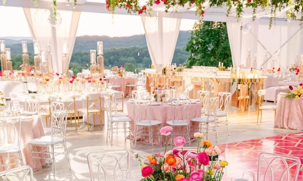 Wedding reception in Big Sky Pavillion featuring pink tablecloths and bright florals.