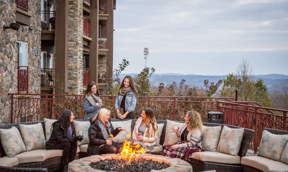 Group of girlfriends sitting around a fire.