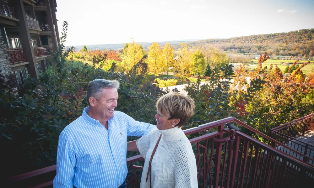 Couple staning on Fire &amp; Water Terrace at GCL overlooking fall foliage.