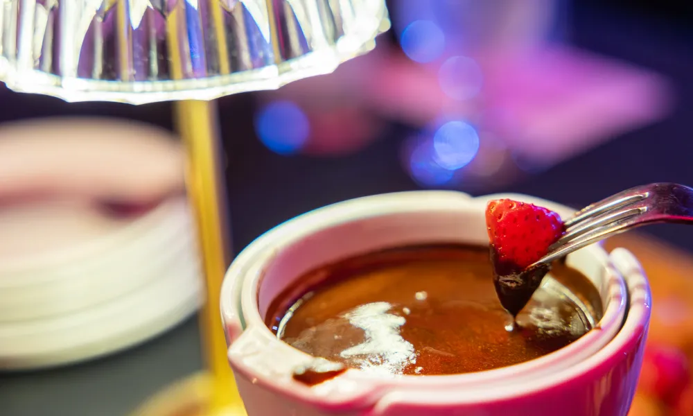 Strawberry being dipped in chocolate at Crystal Cabaret.