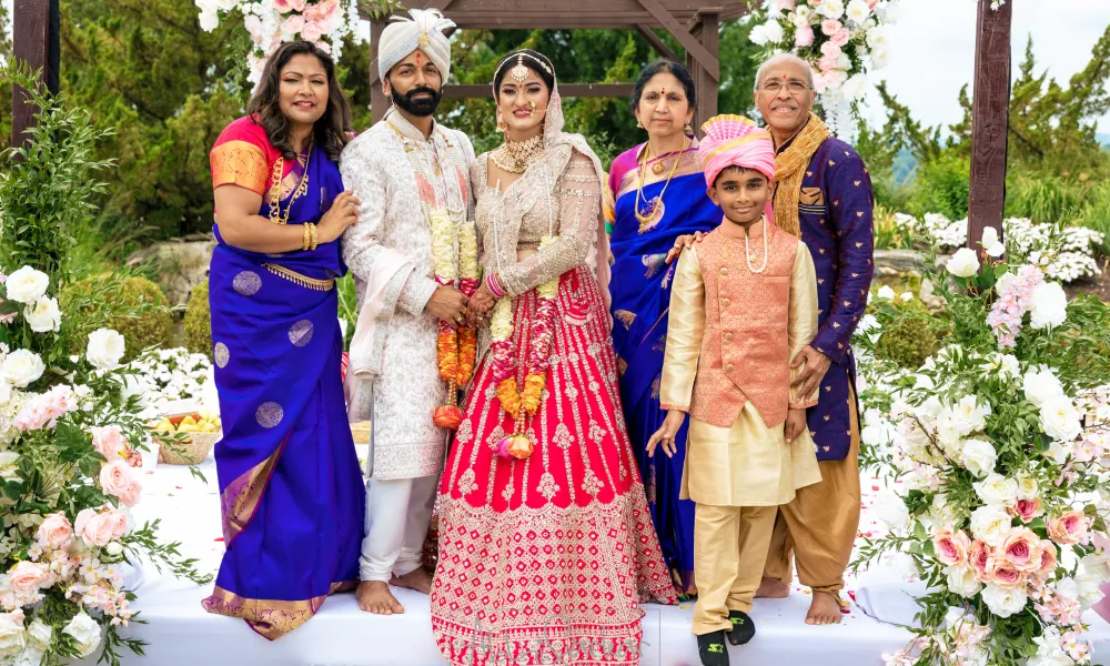 Indian couple standing with their family after getting married at Crystal Springs Resort.