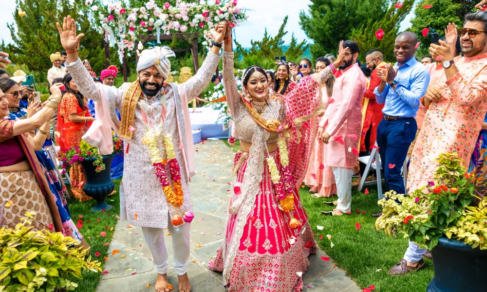 Newly married couple walking down aisle during their Indian wedding ceremony.