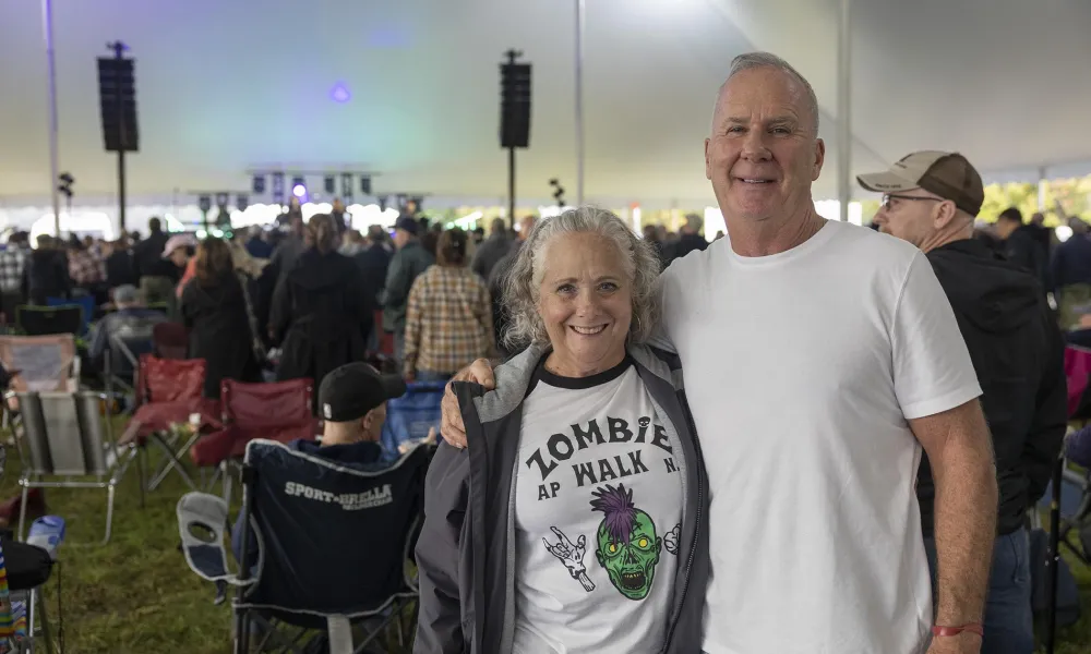 Man and woman standing together with music fest crown behind them.