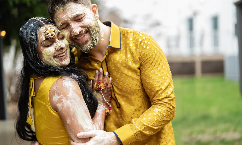 Indian bride and groom wearing gold sarees