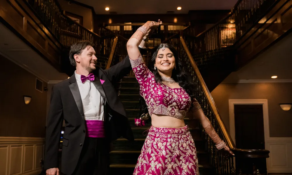 Groom twirling new bride in gorgeous traditional Indian wedding dress