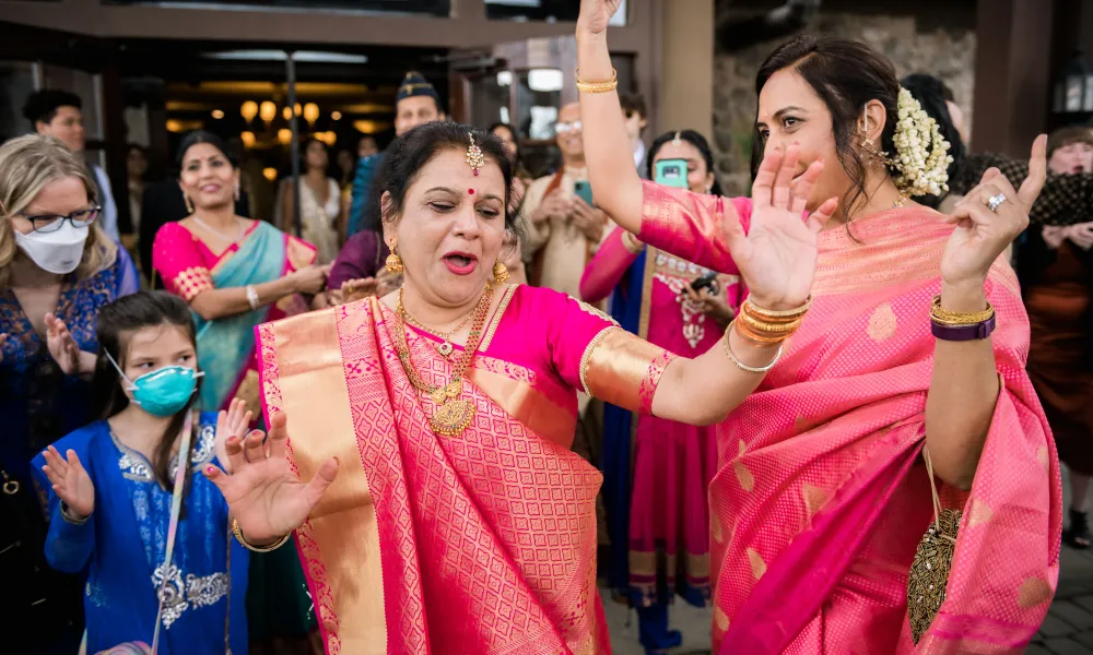 Woman dressed in sarees dancing.