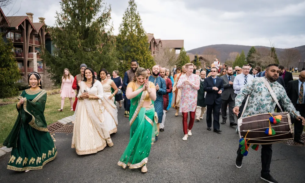 Guests of Indian wedding ceremony walking in front of Grand Cascades Lodge.