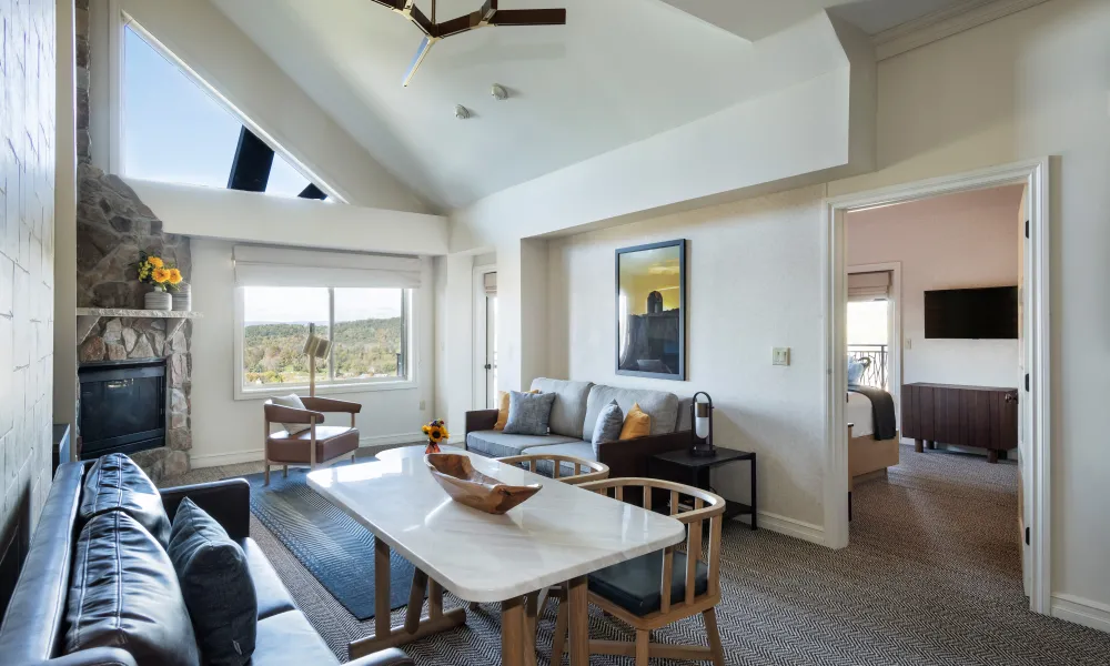 Living room with fireplace and bedroom view in the 2 bed 1 bath suite at Grand Cascades Lodge.