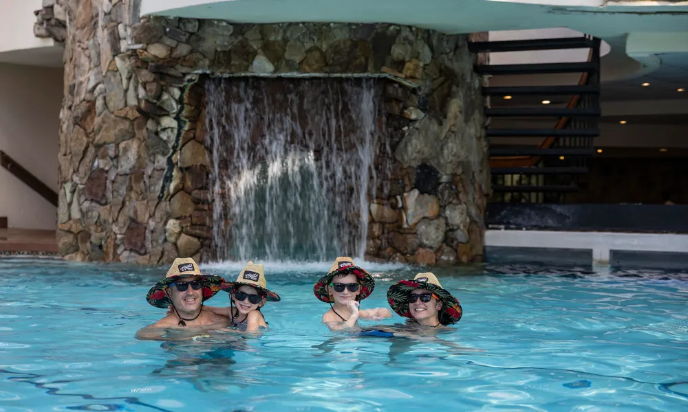 Family of four wearing matching lifeguard hats in Minerals Pool.