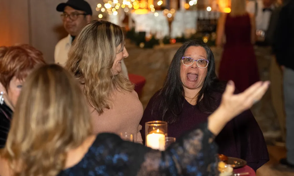 Friends standing around table at holiday party.