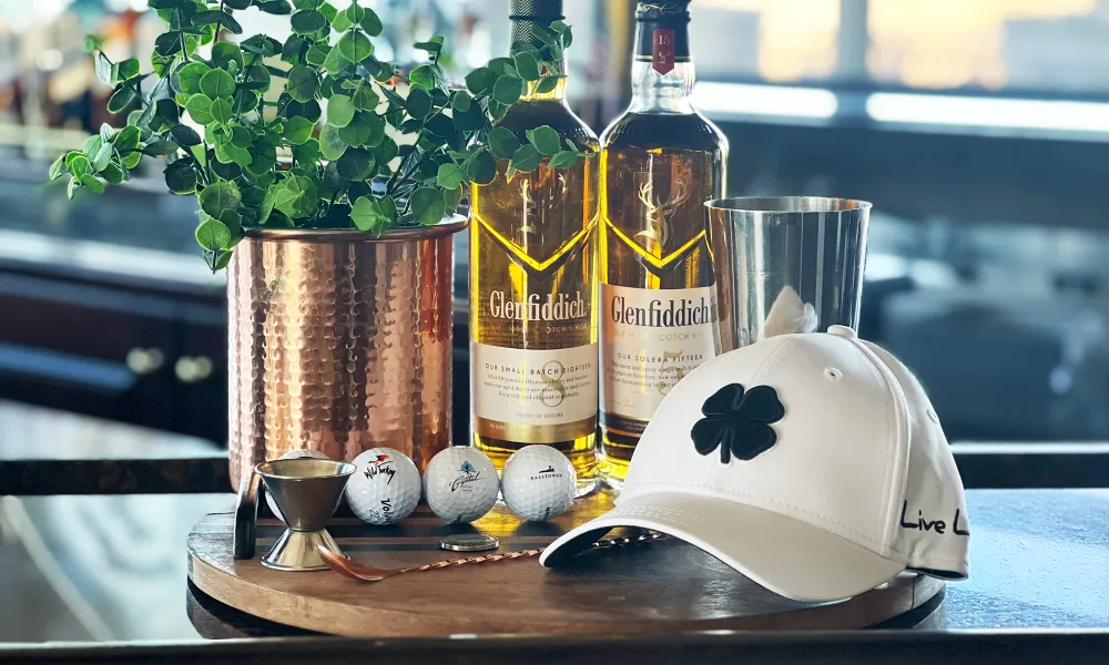 White hat with four leaf clover, three golf balls, Glenfidditch scotch.