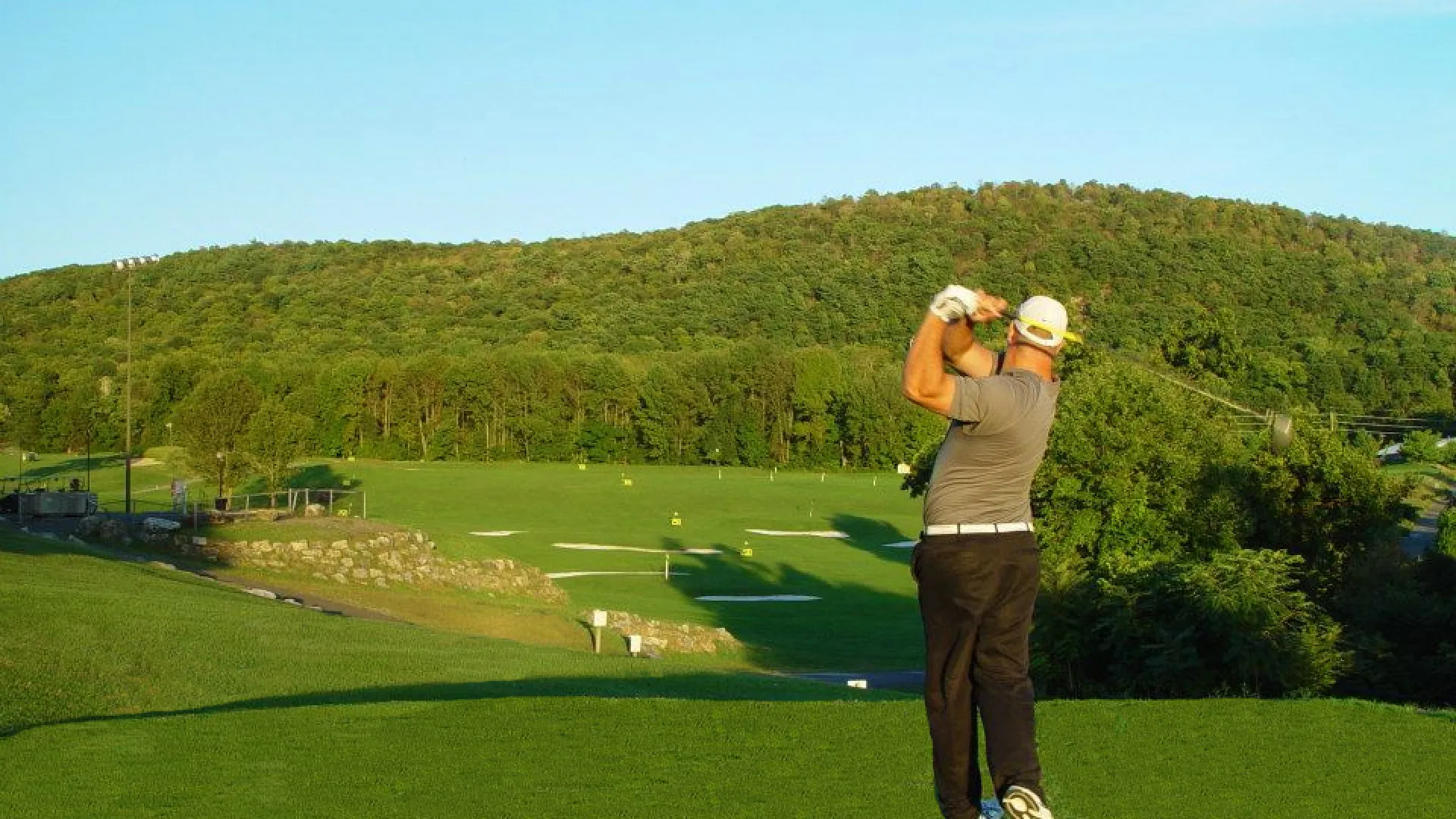 Golfer practicing at the driving range at Black Bear Golf Course