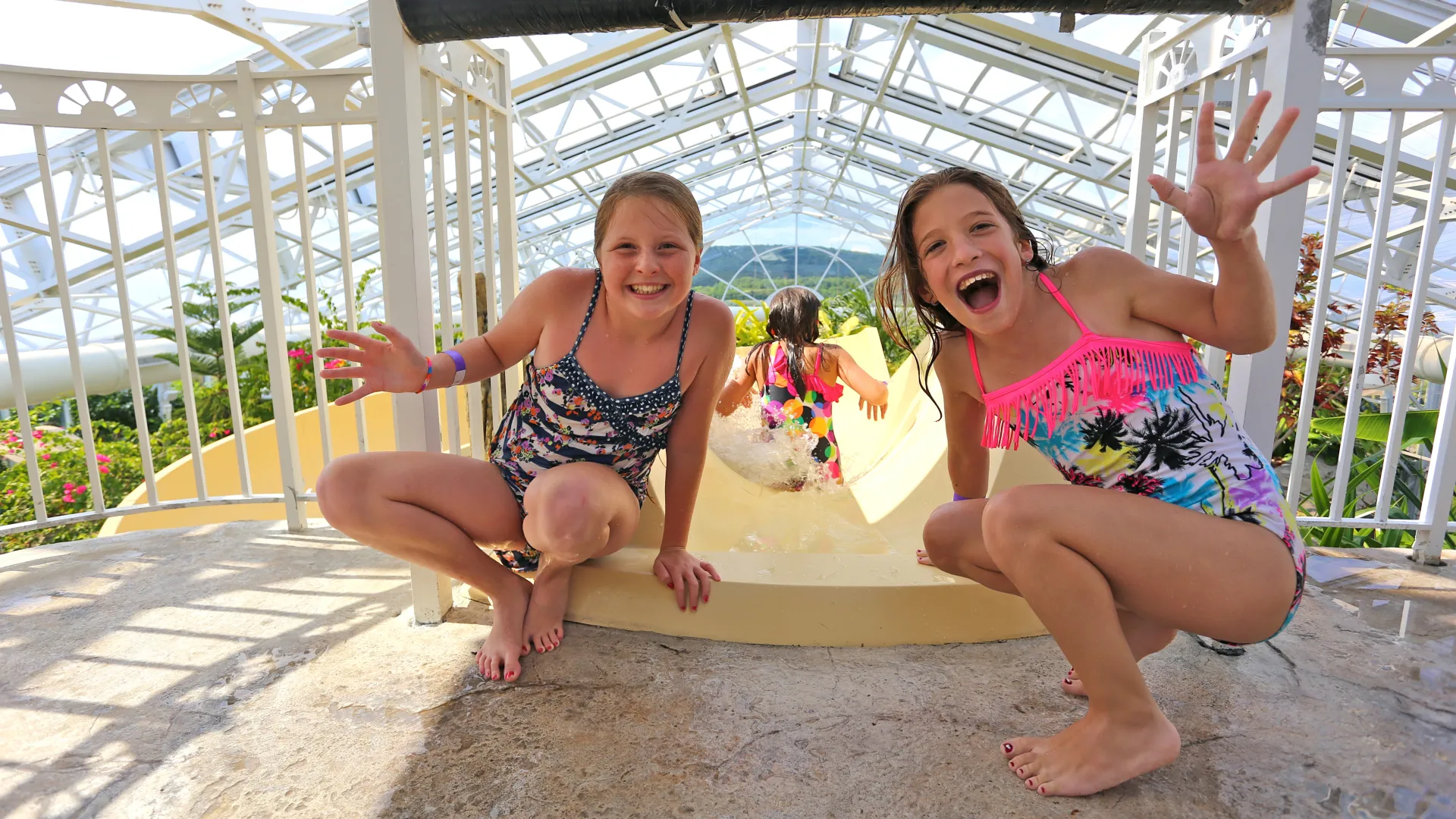 Two girls at top of Biosphere pool complex indoor slide.