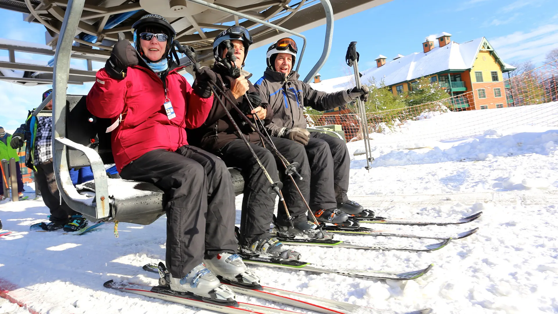 Three people sitting on chair lift at Mountain Creek.