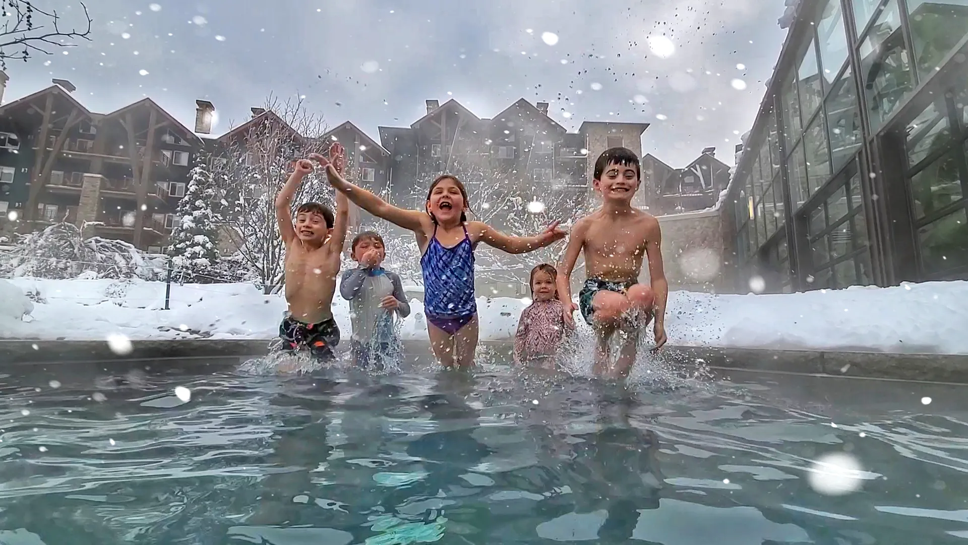 Kids jumping into snow pool at Grand Cascades Lodge 