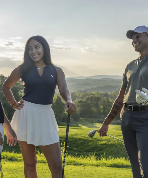 Two women and two men stand together on golf course, 