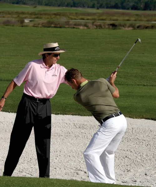 David Leadbetter teaching man how to golf at Crystal Springs Resort