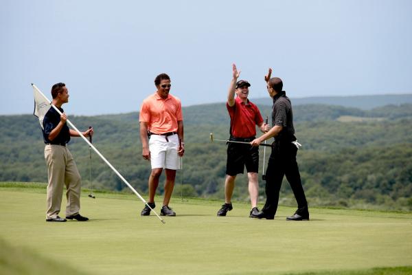 Four golfers on the putting green