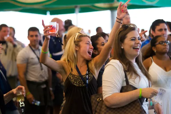 Woman with beer tasting in her hand singing at NJ Beer and Food Festival.