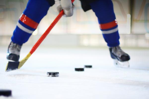 Hockey player practicing shooting hockey pucks