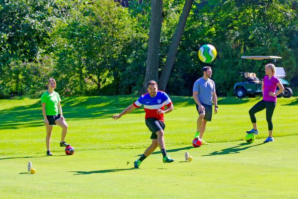 Friends playing a round of foot golf at a resort close to NYC