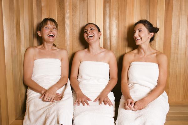 Girlfriends laughing in sauna. 