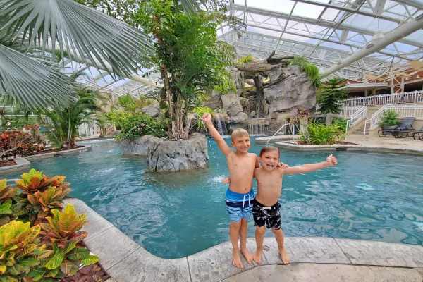 Two boys with their arms around eachother standing outside Biosphere pool.