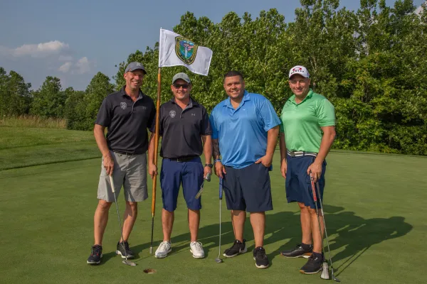 Four guys standing with a law enforcement golf flag at Ballyowen Golf course