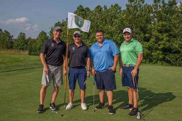 Four guys standing with a law enforcement golf flag at Ballyowen Golf course